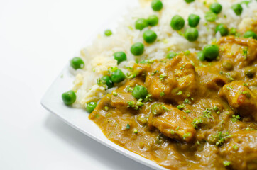 Chicken curry with egg fried rice, chicken breast pieces in a mildly spiced coconut curry sauce with fried rice with peas and egg