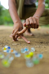 A child playing with glass marbles which is an old Indian village game. Glass Marbles are also called as Kancha in Hindi Language.