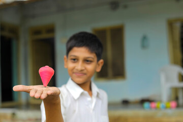 indian child playing with bhovra, Lattu, Bhovra or Bambaram is a traditional throwing top using...