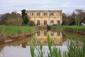 Obraz premium natural panorama with an ancient industrial structure the old dewatering building on the Arno river among the green grass