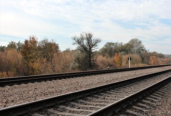 Fototapeta na wymiar Railway tracks under the autumn sky