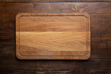 Empty rectangular cutting board on a wooden table. Space for text.