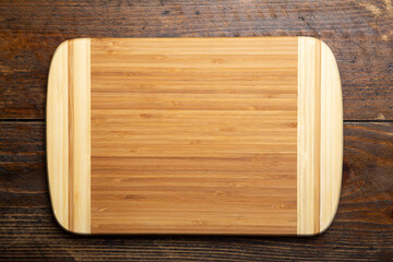 Empty rectangular cutting board on a wooden table. Space for text.