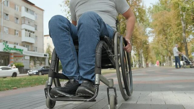 Handicapped man in wheelchair walk at the park alley