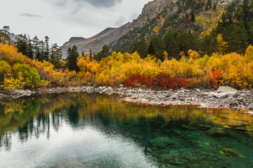 A beautiful alpine lake in the autumn forest. The concept of seasons, vacation and travel
