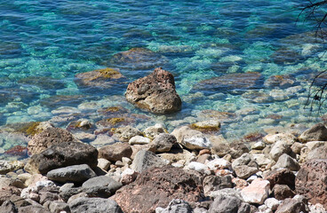 Rocks and stones in crystal clear turquoise water in Mallorca, Balearic Islands, Spain