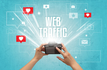 Close-up of a hand taking photos with WEB TRAFFIC inscription, social media concept