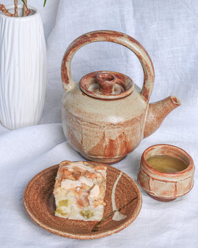 Ceramic tea cup with green tea. Ceramic teapot. Japanese green tea Genmaicha. Homemade pie. Charlotte.