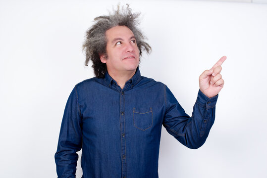 Smiling Handsome Mature Caucasian Man With Afro Grey Hair Standing Over Isolated White Background Pointing Up And Looking At The Camera