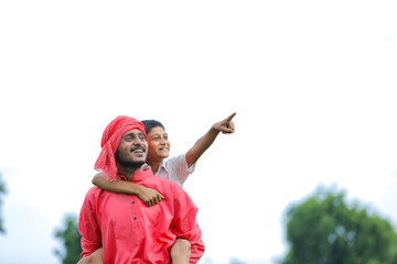 Indian farmer playing with his child at green field