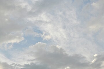 Fototapeta premium Light blue sky with light gray and white clouds in diffused light