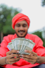 Young indian farmer counting money
