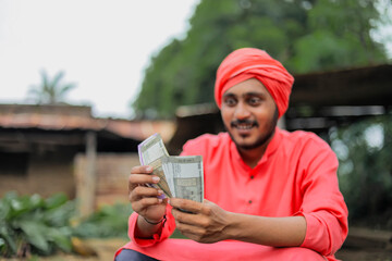 Young indian farmer counting money