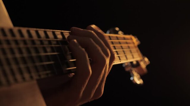 Playing acoustic guitar fretboard closeup