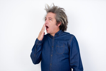 Handsome mature caucasian man with afro grey hair standing over isolated white background being tired and yawning after spending all day at work.