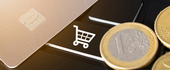 Credit card, coins and shopping card icon on the black keyboard. Online shopping concept