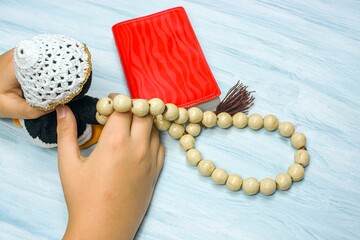 children's hands with rosary and prayer book on the table, background of religion