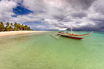 Banka, traditional Philippine outrigger boat off the beach.