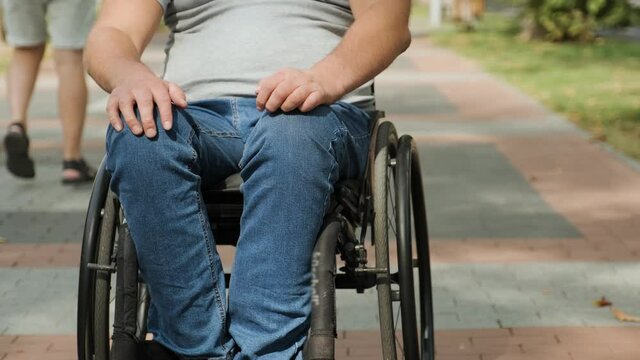 Handicapped man in wheelchair walk at the park alley