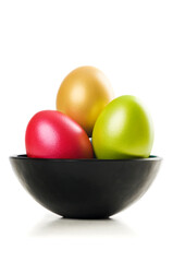 Group of colored Easter Eggs in saucer on white background. A bunch of pearl colored easter eggs in black saucer isolated on white with shadow. Studio shot.