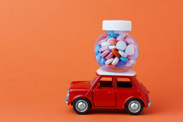 red toy car delivering a bottle of pills.  Internet pharmacy, online order. 