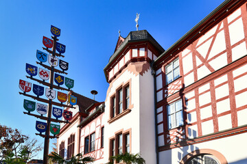 Lorsch, Germany, Traditional guild pole and part of old historic city hall building in front of blue sky