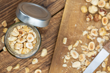 Portion of freshly chopped Hazelnuts (close up; selective focus)