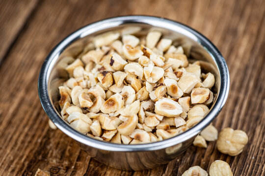Freshly chopped Hazelnuts on an old wooden table (close up; selective focus)