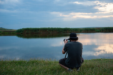 A man making photo wiha a camera in forward a landscape