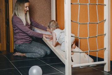 Active games for Baby indoors activities. Toddler girl play with mom on home Wooden playsets. Play...