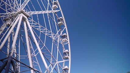 In the park, a large Ferris wheel is spinning slowly. High-altitude view wheel