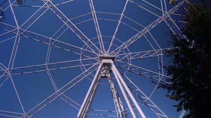 Obraz premium In the park, a large Ferris wheel is spinning slowly. High-altitude view wheel
