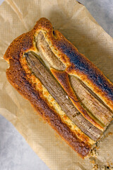 Homemade Vegan Gluten Free Banana Bread Sugar Free. Oatmeal bread with banana, honey and nuts in a baking dish on a gray table surrounded by ingredients. Top view, flat lay. Healthy sweets concept
