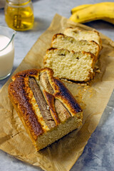 Homemade Vegan Gluten Free Banana Bread Sugar Free. Oatmeal bread with banana, honey and nuts in a baking dish on a gray table surrounded by ingredients. Top view, flat lay. Healthy sweets concept