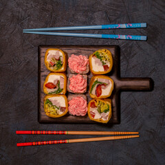Sushi on a wooden board.Top view on dark table background.Japanese food. Still life
