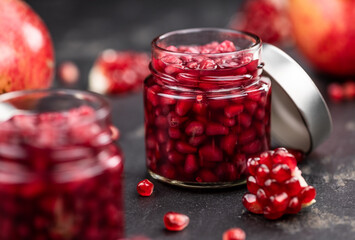 Fresh made preserved Pomegranate seeds on a slate slab (close-up shot; selective focus)