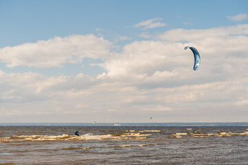 The kitesurfer is riding on the waves of the Bay.
