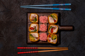 Sushi on a wooden board.Top view on dark table background.Japanese food. Still life