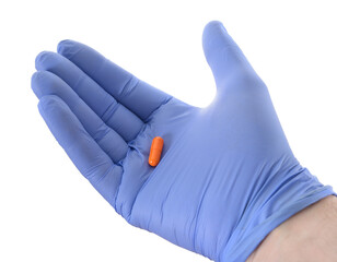 Hand in latex medical glove holding capsule drugs
