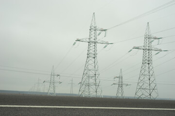 Power lines in a foggy field in winter