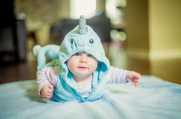 Baby narwhal doing superman tummy time exercises holiday halloween costume