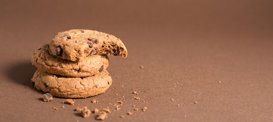 American chocolate chip cookies with chocolate on a brown warm background. Delicious dessert, close up. Space for text. Tasty offer