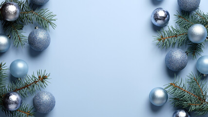 Blue Christmas background with pine tree branches and shiny balls decoration. Xmas frame, greeting card template, banner mockup. Flat lay, top view, copy space.