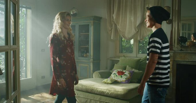Cinematic shot of an young carefree happy smiling homosexual female gay and transgender man couple in love is enjoying to pass time together and holding hands of each other with affection at home.