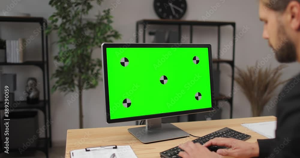 Poster handsome office worker in business suit using modern computer at bright office. empty green screen. 