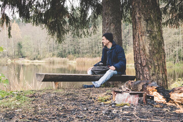 Fototapeta premium happy smile traveller on a halt in the woods by the lake