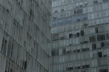 Fototapeta premium View of a building full of windows, in a green/blue tone