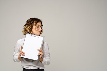 Naklejka premium Business woman in a light shirt and a folder with documents in hands cropped view of work