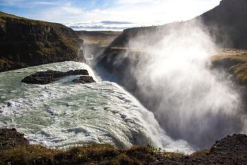 GULLFOSS, ICELAND, SEPTEMBER 19, 2018: Mist rising from famous waterfall located in the canyon of the Hvítá river in southwest Iceland. Sunny day during autumn.