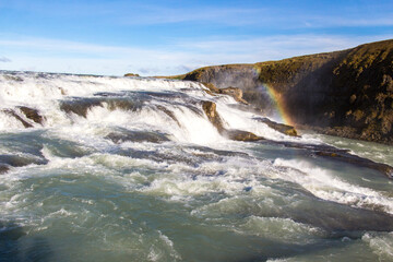 GULLFOSS, ICELAND, SEPTEMBER 19, 2018: Famous waterfall located in the canyon of the Hvítá river in southwest Iceland during autumn. Rainbow over water.